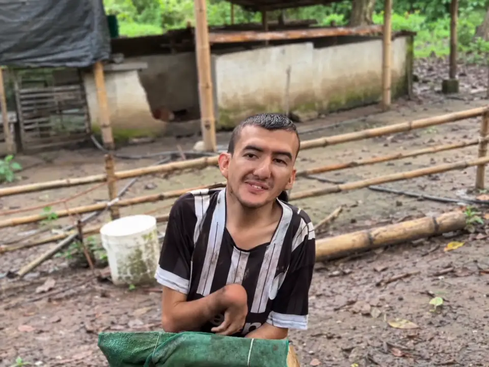 Goyito looking toward the camera beside his wooden support, adapted from campaign footage